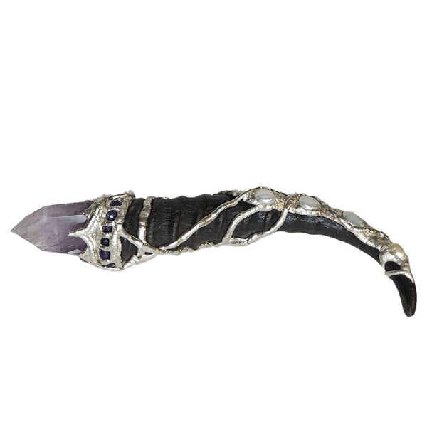 A blesbok horn is adorned with a polished amethyst point. On the handle there is three white coin pearls, a large white pearl and a small white pearl. Six small faceted amethyst beads with a labradorite cabochon. Back view.
