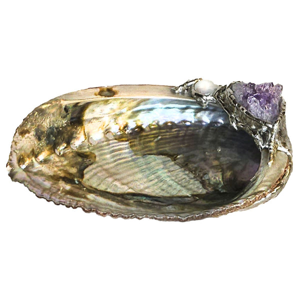 An amethyst cluster is set with a white coin pearl on this abalone shell jewelry bowl.