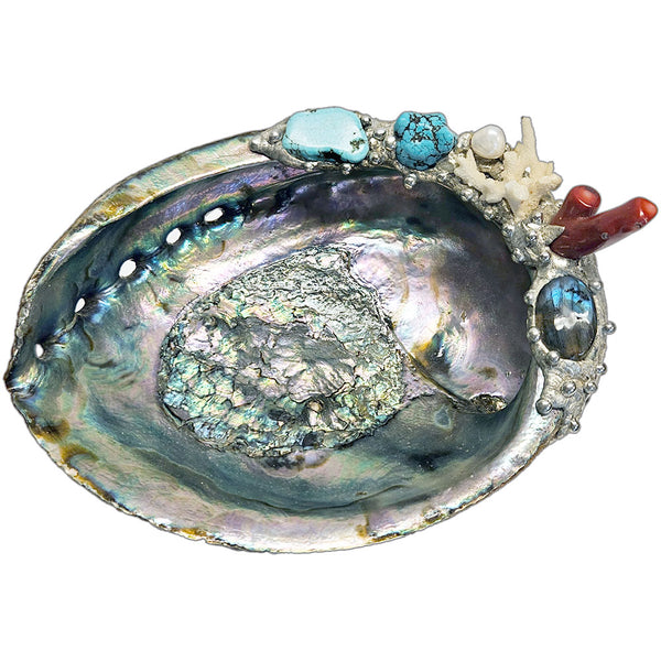 Decorative abalone shell with turquoise stones, coral on a white background top view