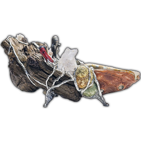 A mermaid rests on a large pink abalone shell, adorned with corals, seashells, gemstones and driftwood side view