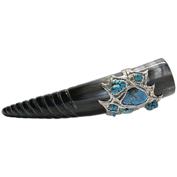 a drinking horn made from steer with a spiral carving at the bottom, two turquoise cabochons, two turquoise nugget and three small turquoise nuggets and three mermaid tears side view
