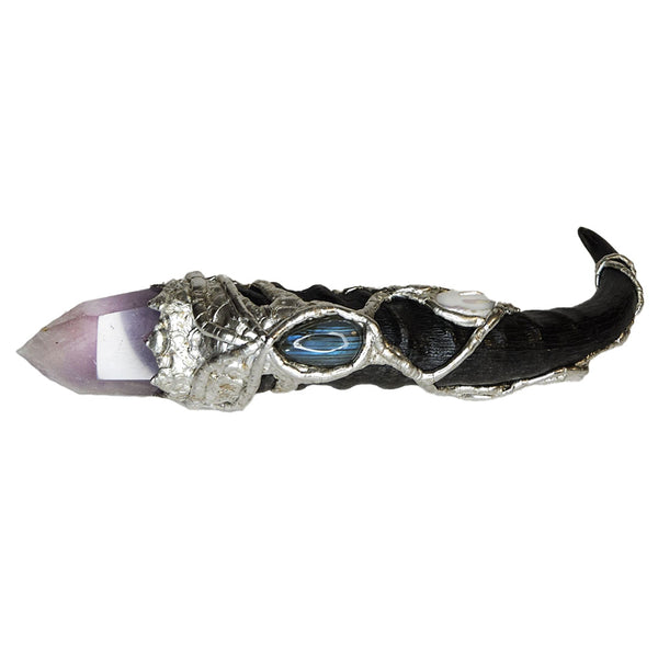 A blesbok horn is adorned with a polished amethyst point. On the handle there is three white coin pearls, a large white pearl and a small white pearl. Six small faceted amethyst beads with a labradorite cabochon. Front view.
