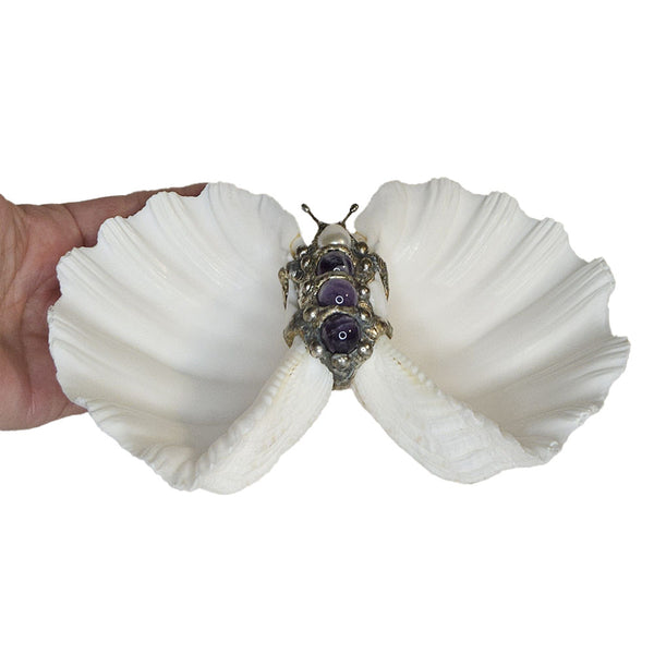 Two bear claw clam shells have been set together to form this shell bowl adorned with three large amethyst balls and a large white pearl. Comes with a leucite stand. Dress up any table for special occasions.