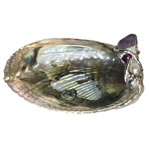 This small abalone shell is graced with a lovely amethyst point, small purple pearl and a small white pearl. Comes with a leucite stand.