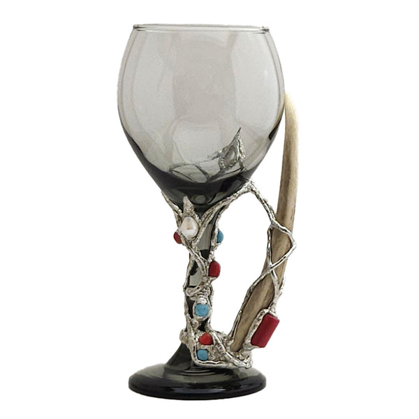 Wrapped around a 13.5 oz smoky red wine glass with a deer antler. You will find four red coral beads and a red branch coral that is set on the deer antler. Three turquoise balls and two small white pearls add just the right accent to this exclusive one and only wine glass. Front view.