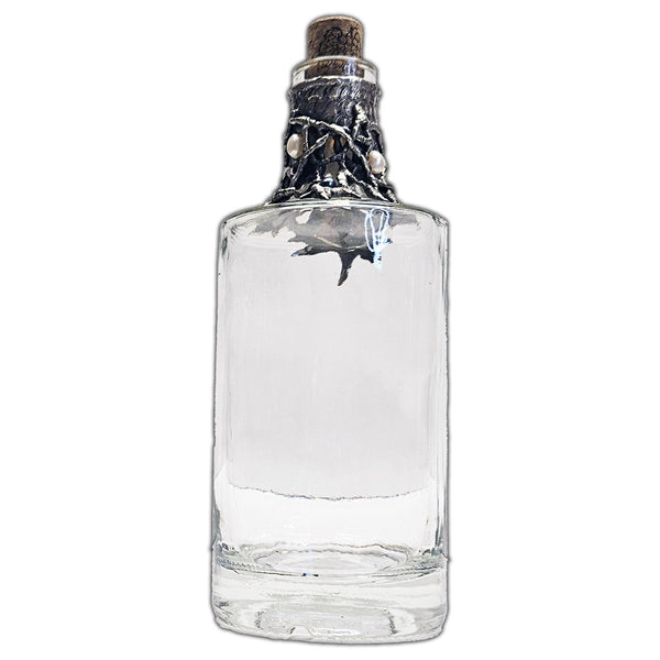 Repurposed rum bottle decanter featuring a silver pirate’s piece of eight at its center, adorned with seven luminous white pearls side view