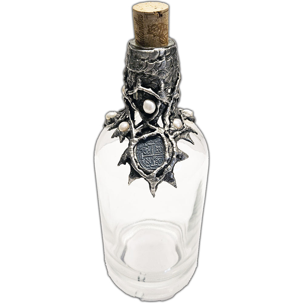 Repurposed rum bottle decanter featuring a silver pirate’s piece of eight at its center, adorned with seven luminous white pearls top iew