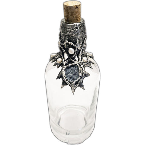 Repurposed rum bottle decanter featuring a silver pirate’s piece of eight at its center, adorned with seven luminous white pearls top iew